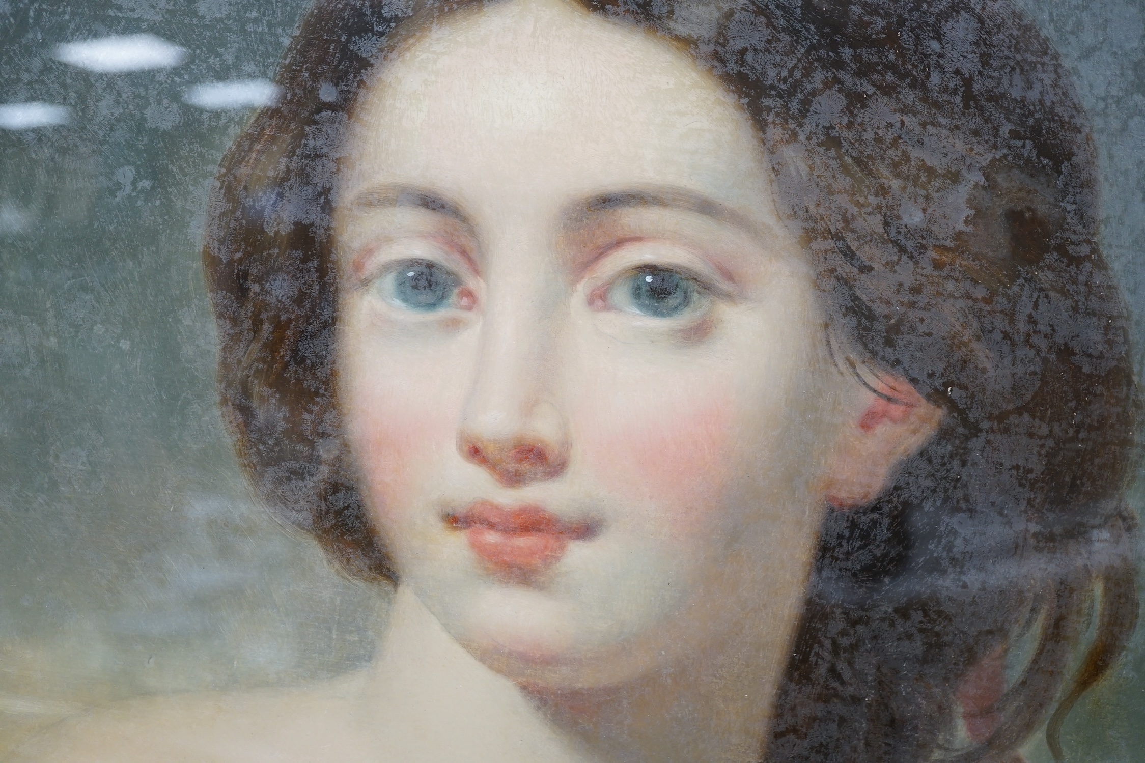 19th century School, reverse glass painted oval panel, Study of a young beauty, 44 x 36cm, housed in a gilt frame. Condition - poor to fair